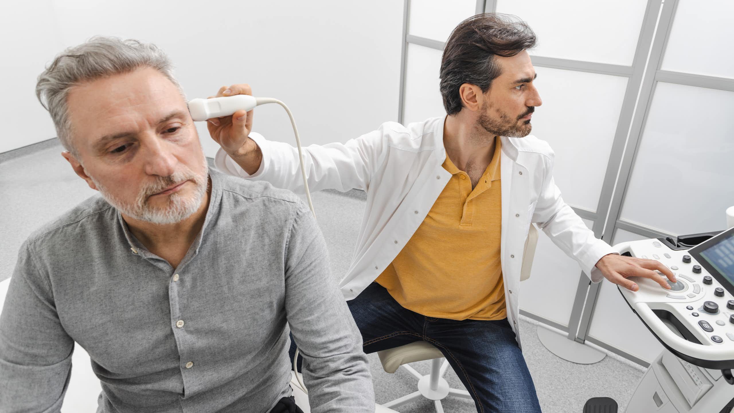 Un soignant pratique un examen sur un patient à l’aide d’ultrasons.