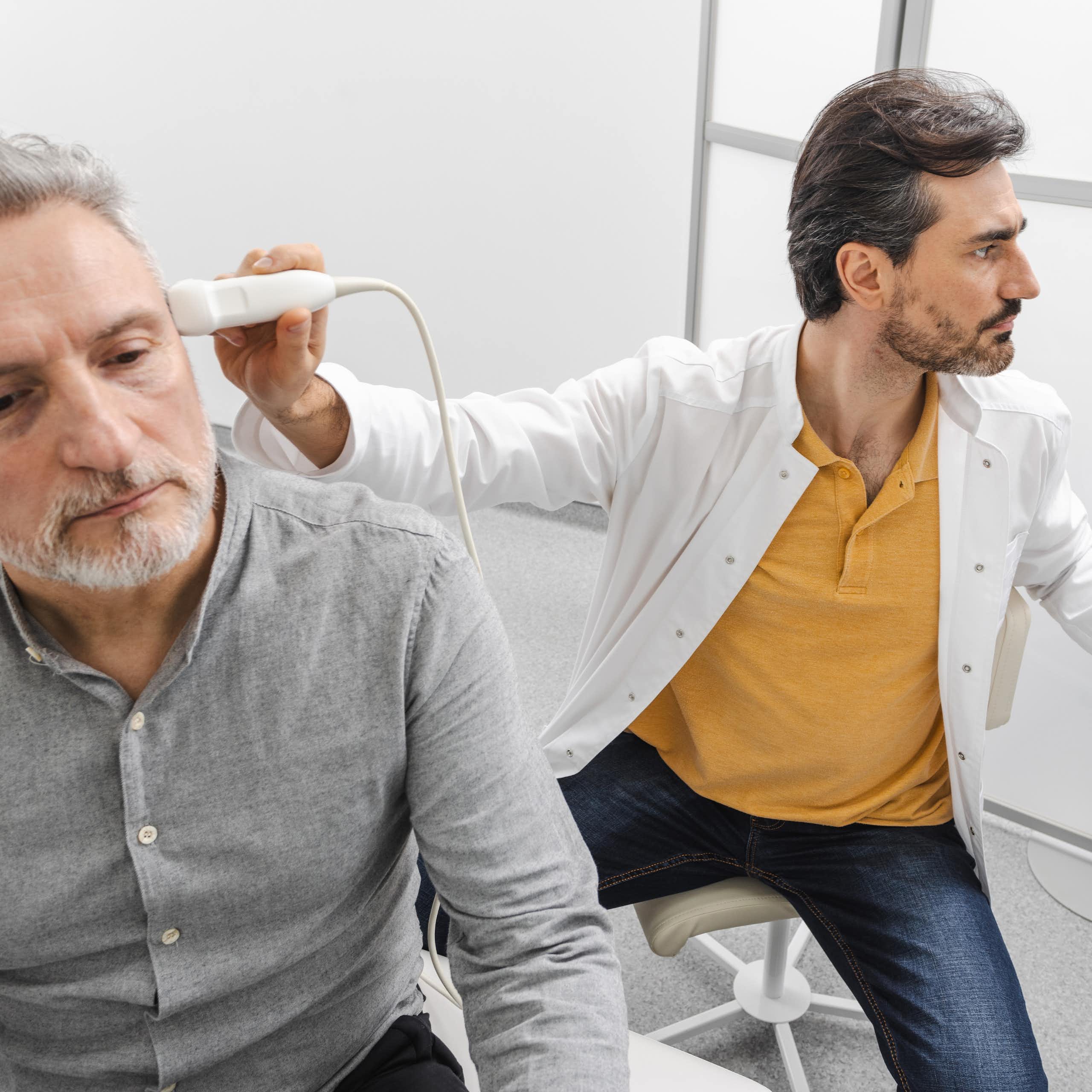 Un soignant pratique un examen sur un patient à l’aide d’ultrasons.