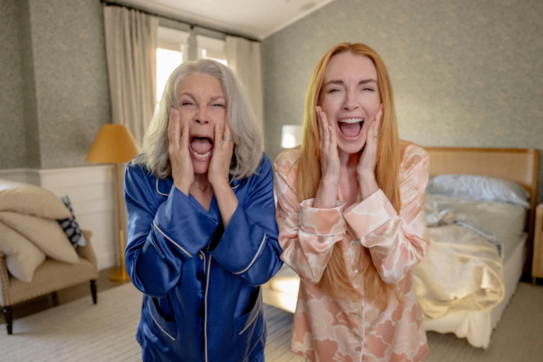 Lindsay Lohan and Jamie Lee Curtis holding their faces and screaming