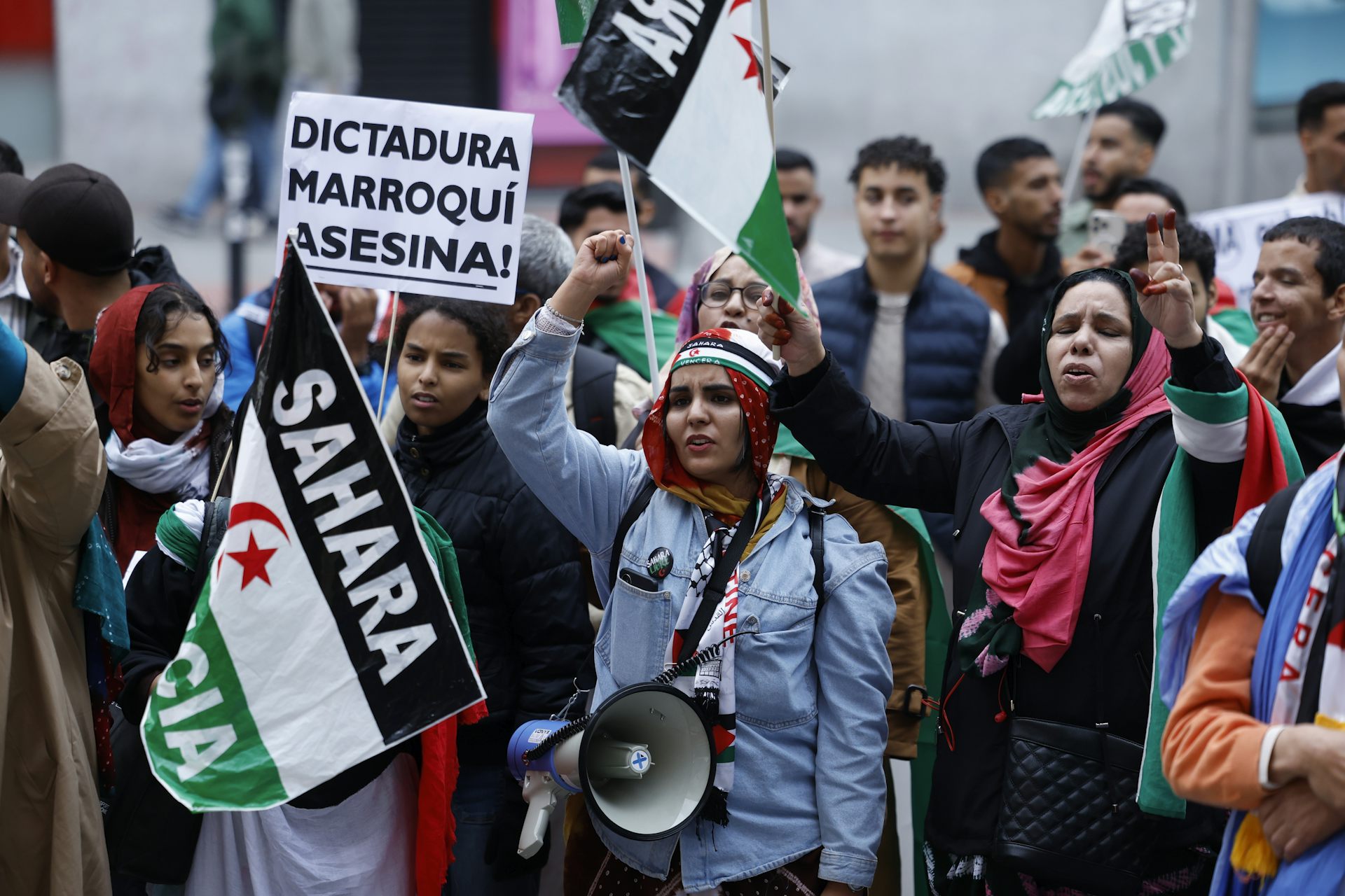 A group of people hold banners as they demonstrate for the Sahrawi people's right to self-determination.