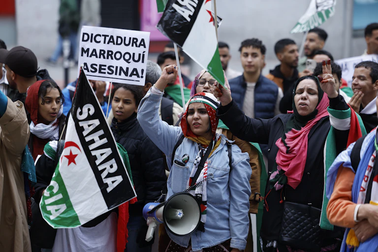A group of people hold banners as they demonstrate for the Sahrawi people's right to self-determination.