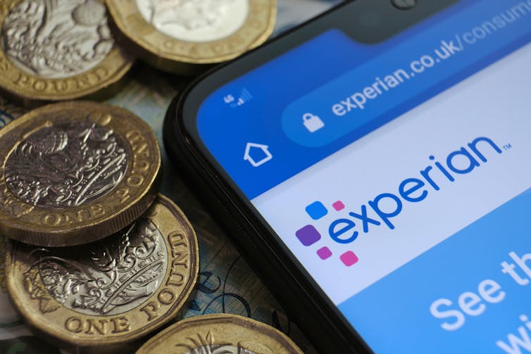 home screen of experian website on a phone surrounded by pound coins