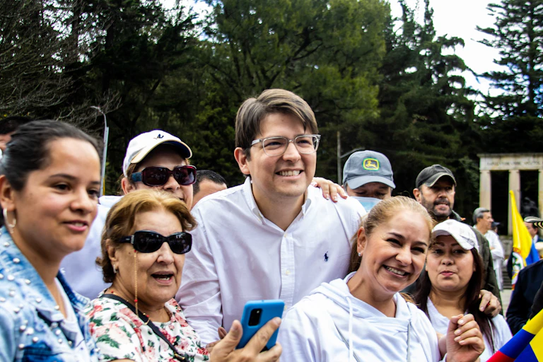 Un hombre sonriente junto a otras personas en el transcurso de una manifestación