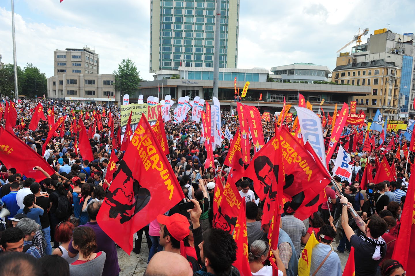 A large crowd of protesters waving red flags in Istanbul