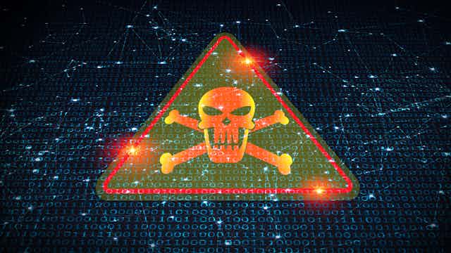 a bright red triangle surrounding a skull and cross bones against a backdrop of ones and zeros