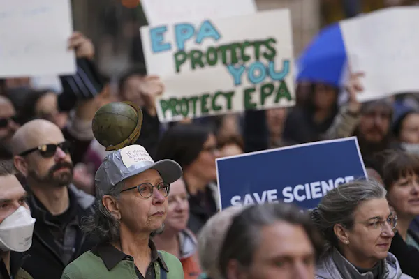 A group of people hold science reading 'EPA protects you, protect EPA' and 'Science saves'