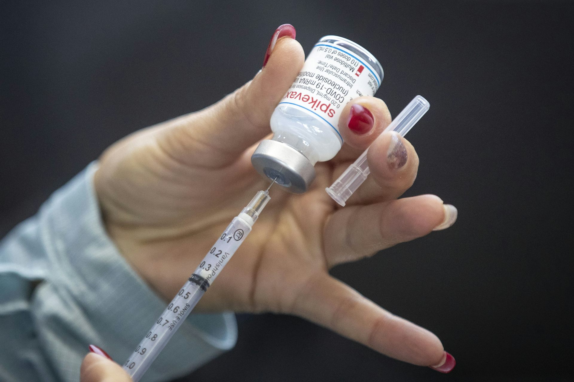 Une personne tient une dose de vaccin dans sa main