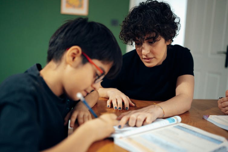 an older student helping a younger student with their homework