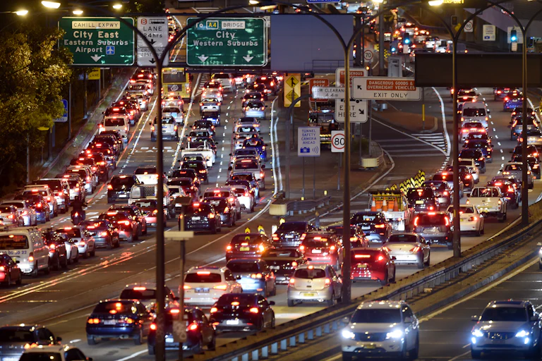 Cars queued on freeway at night.