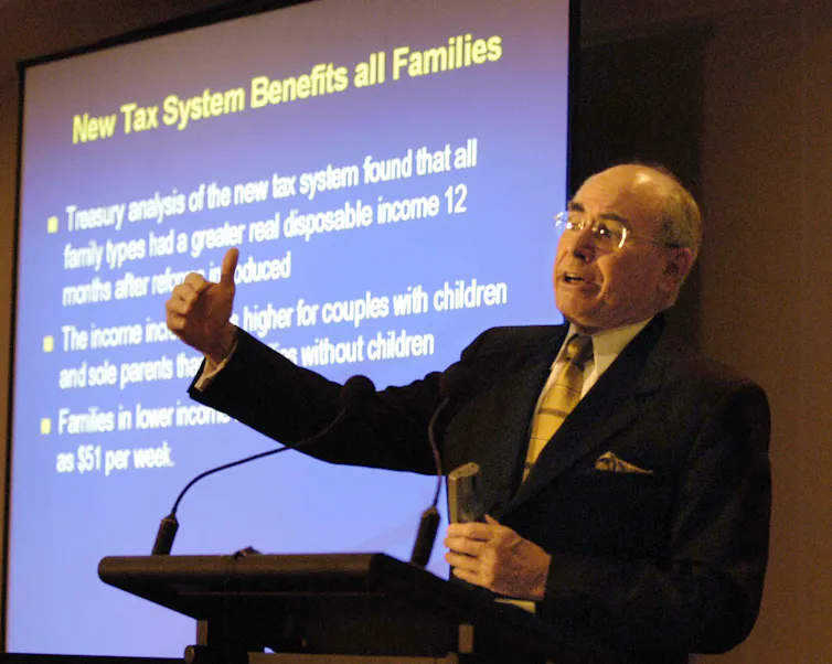John Howard in 2003 stands in front of a tax presentation and gives a speech