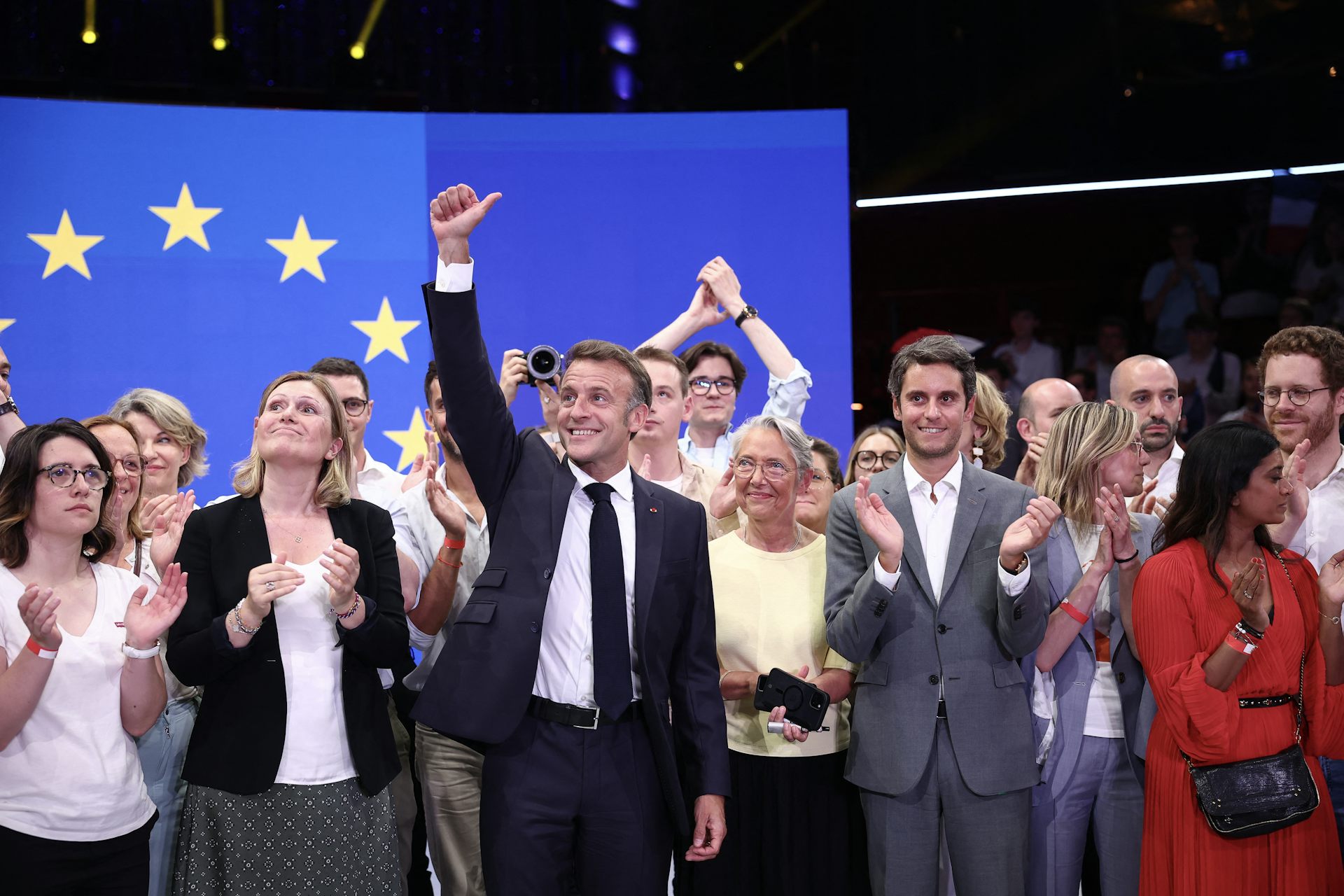 Emmanuel Macron et Gabriel Attal posent avec plusieurs figures du mouvement macroniste devant un drapeau européen. 
