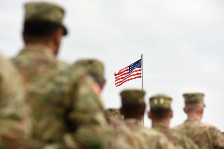 American soldiers in the foreground of the US Flag