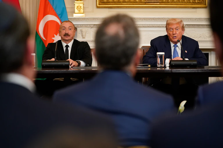 Ilham Aliyev and Donald Trump sat at a table as they speak to the media.