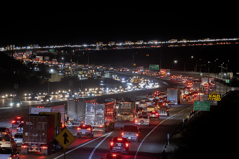Vehicles on a highway at night, their taillights highlighting the s curves of the highway.