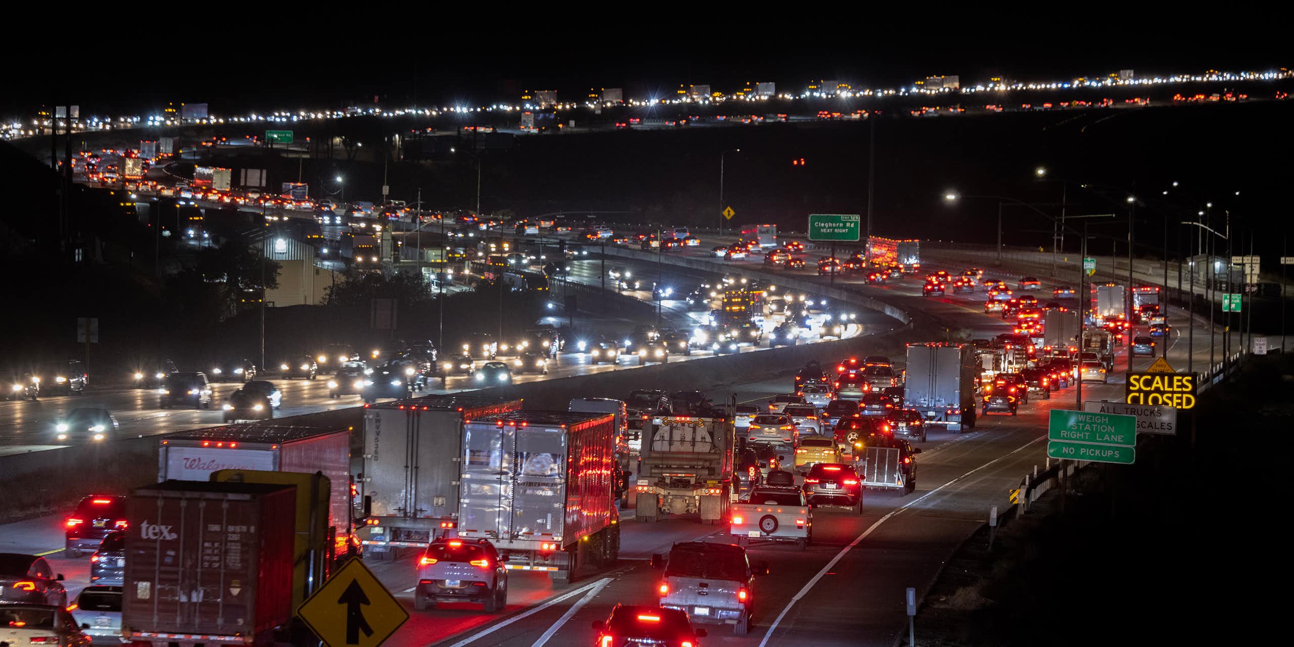 Vehicles on a highway at night, their taillights highlighting the s curves of the highway.