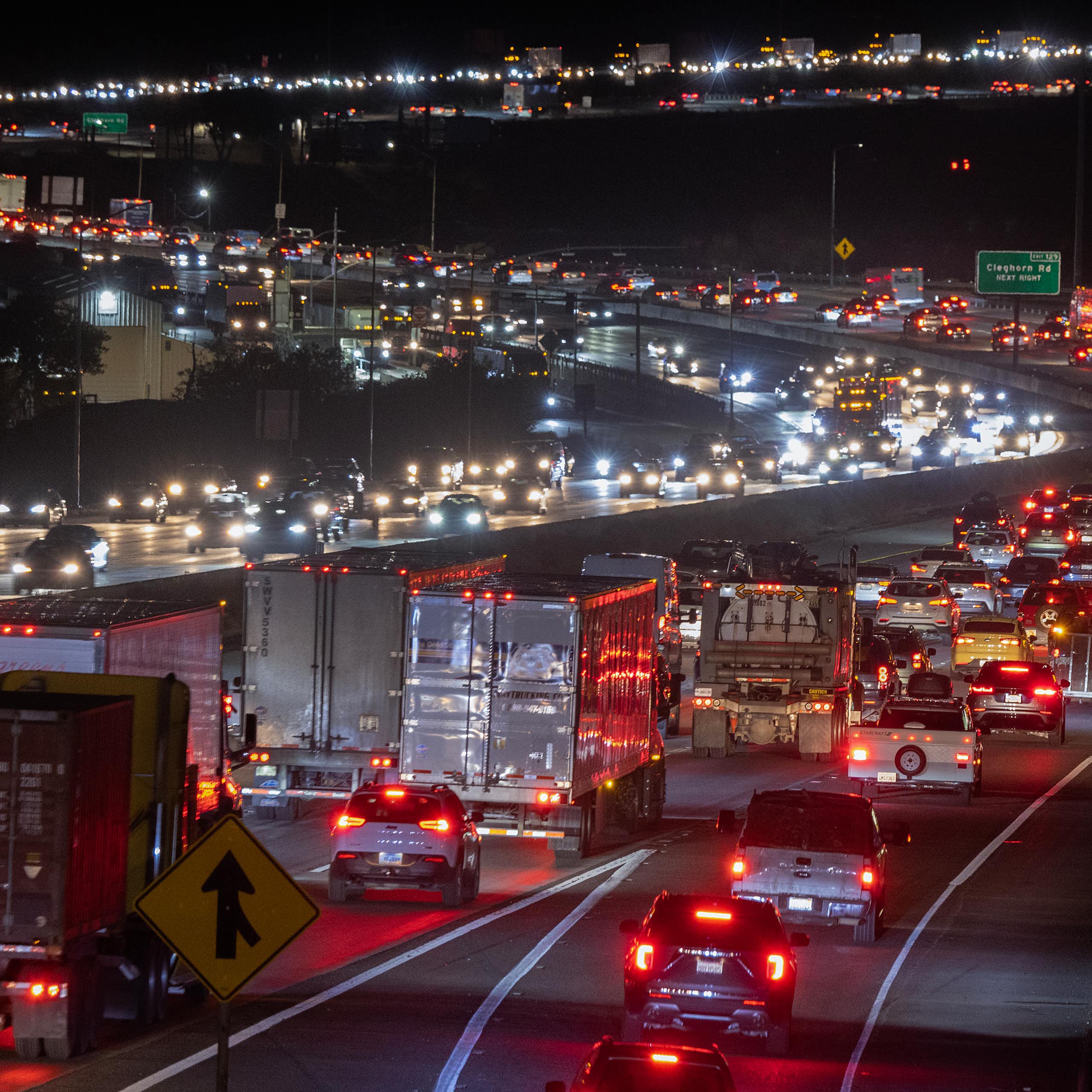 Vehicles on a highway at night, their taillights highlighting the s curves of the highway.