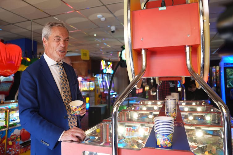 Nigel Farage playing an arcade game.