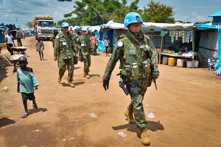 A group of Japanese troops patrolling a street in South Sudan on foot.