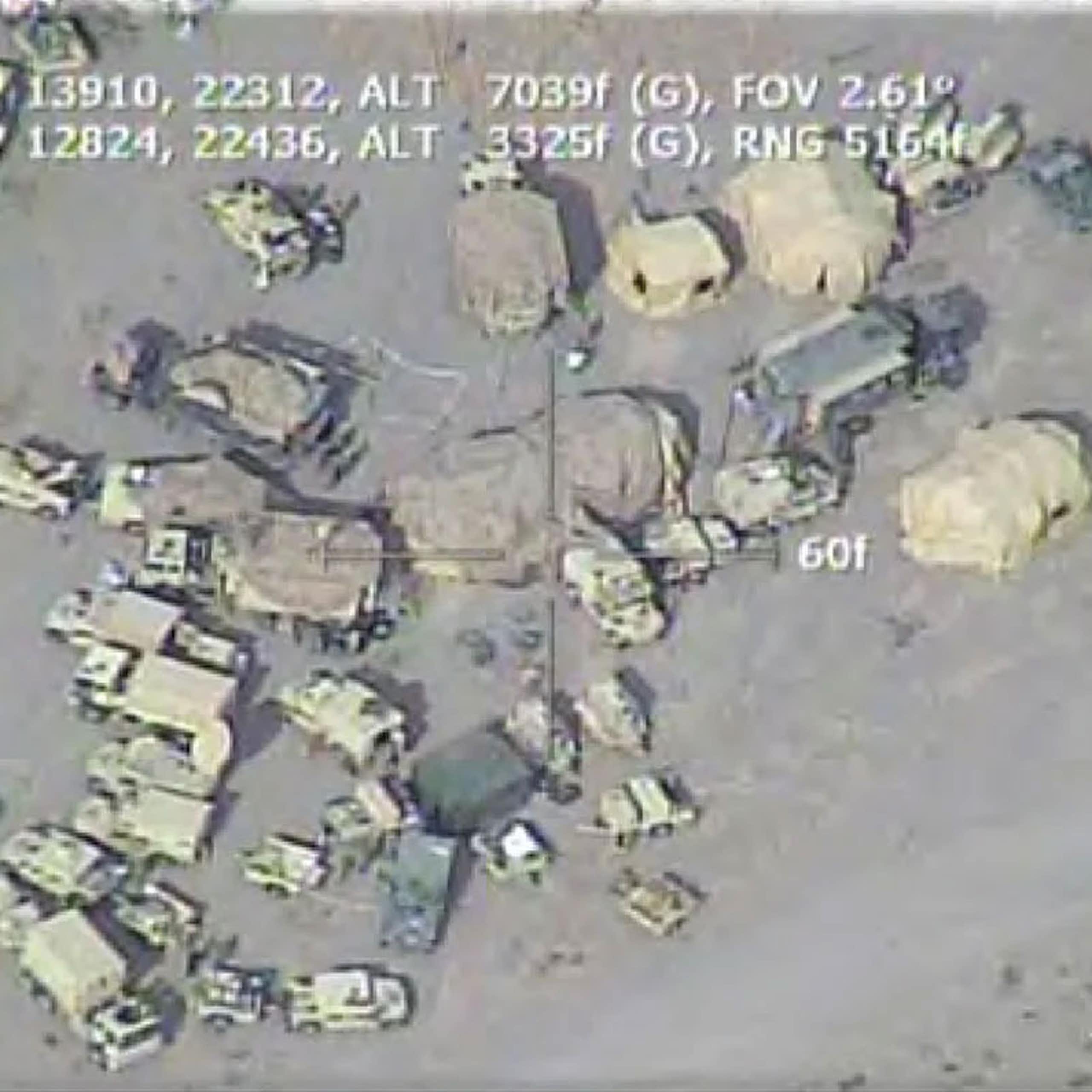 aerial view of a cluster of military vehicles in a desert