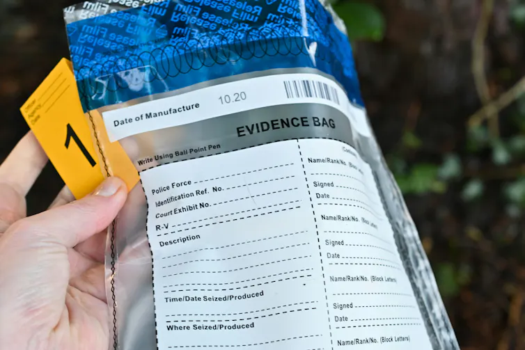 a hand holding an evidence bag