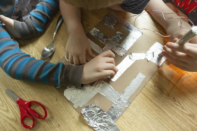 Students working on science project together on floor.