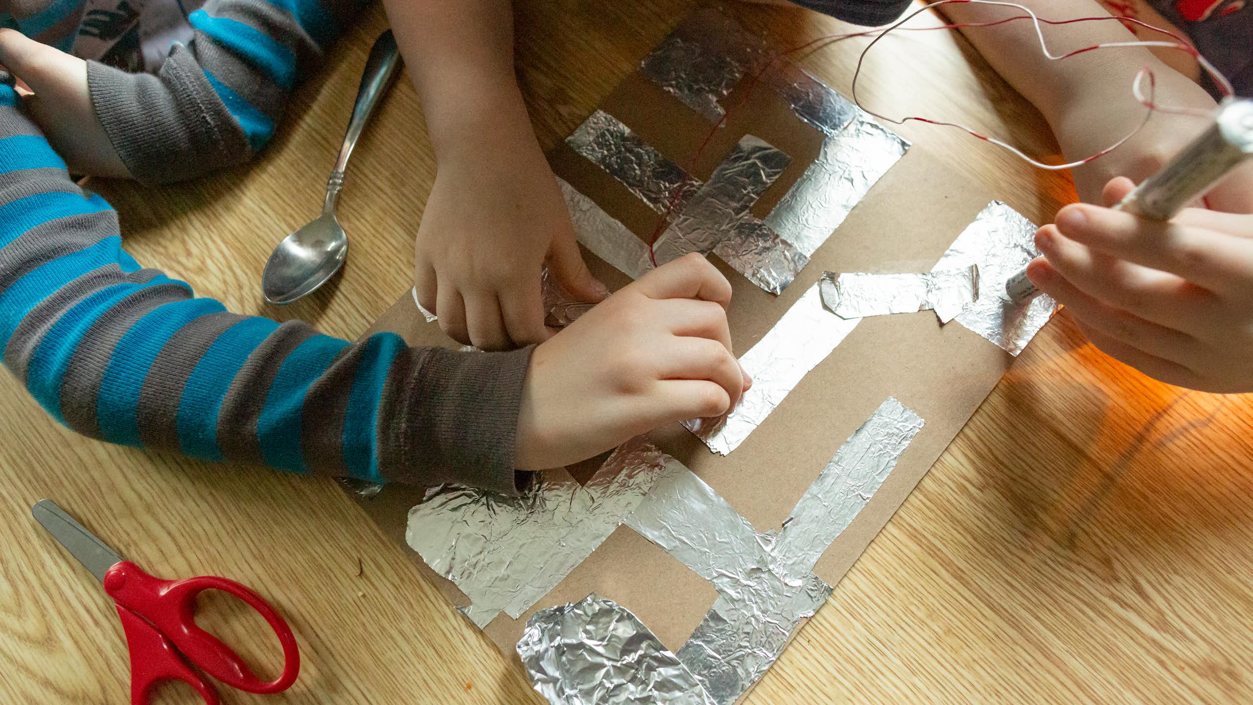 Students working on science project together on floor.