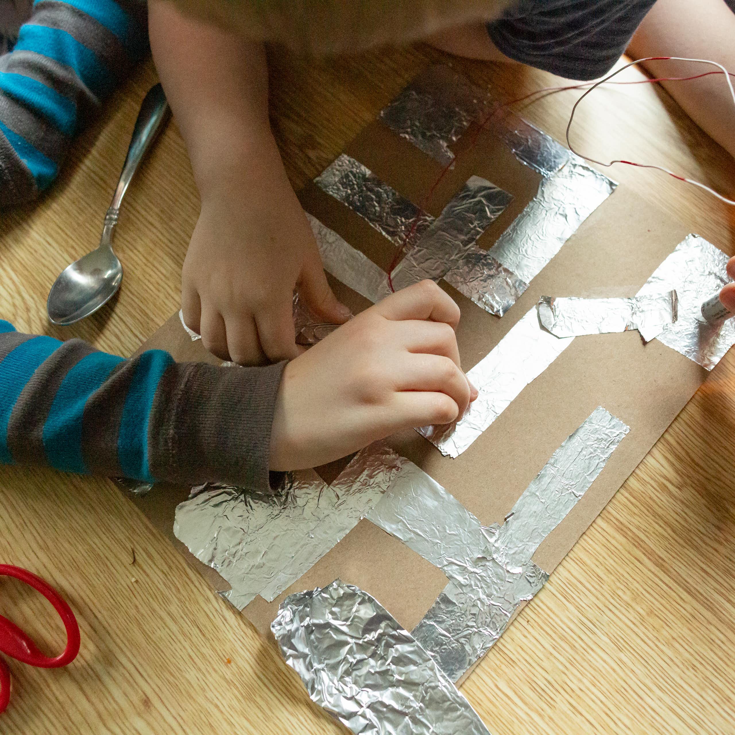 Students working on science project together on floor.