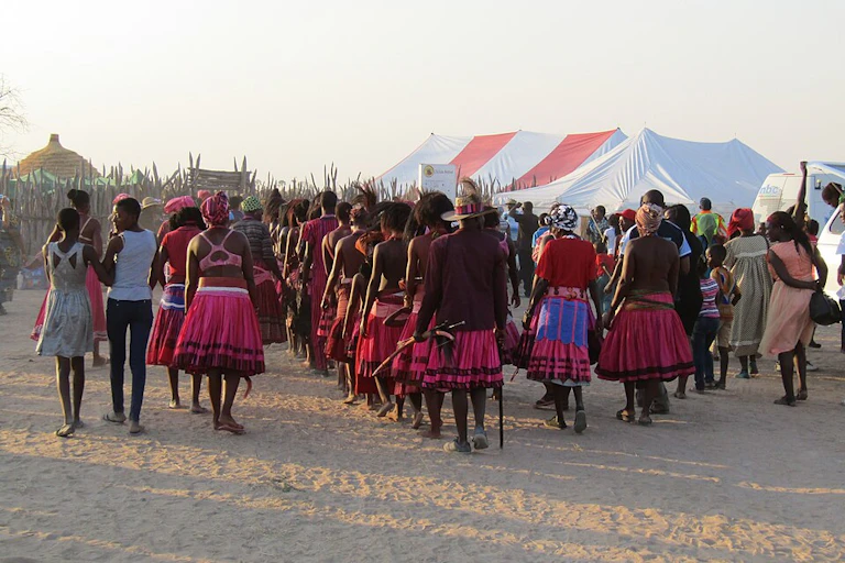 Rows of people in pink skirts