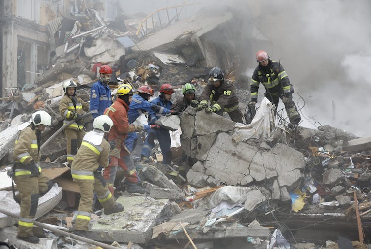 Rescuers search through rubble at the site of a Russian strike on a nine-storey residential building in Kyiv.