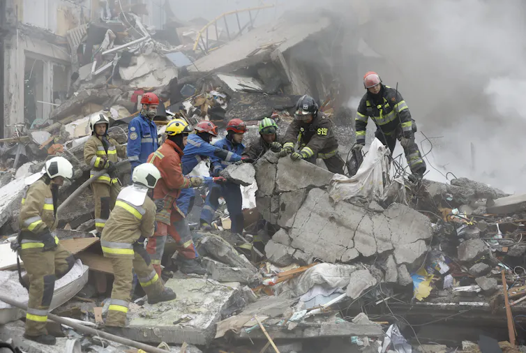 Rescuers search through rubble at the site of a Russian strike on a nine-storey residential building in Kyiv.