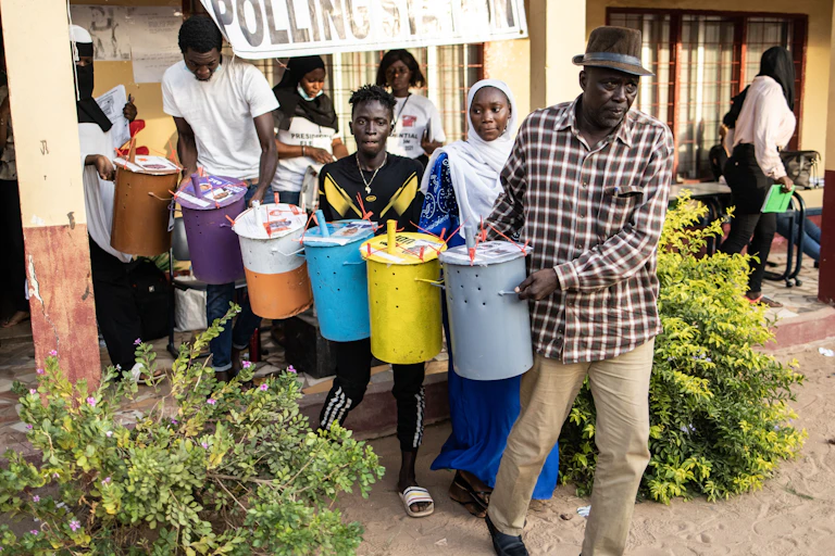 People carrying sealed bins