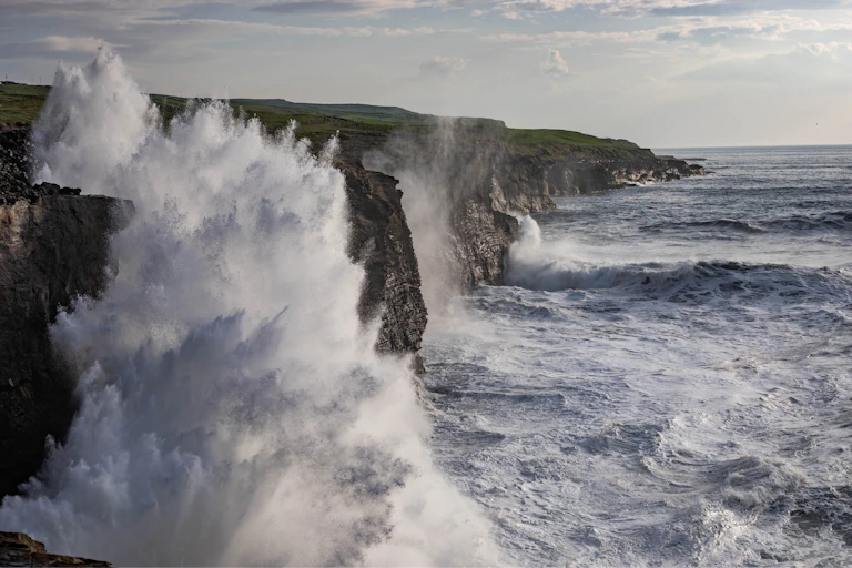 Rough ocean waves slam into cliffs