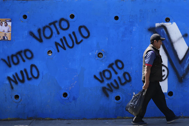 A man walks by political graffiti.