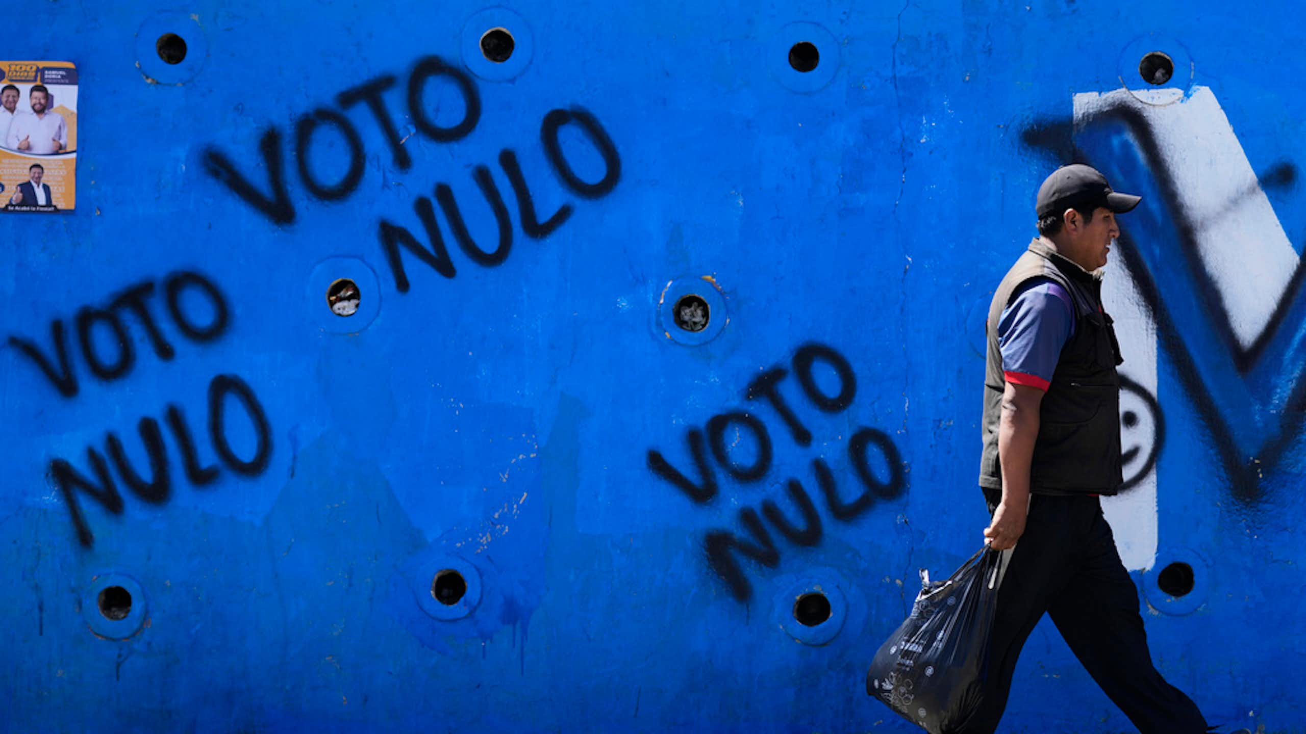 A man walks by political graffiti.