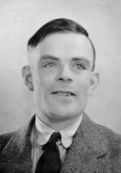 Black and white portrait of young man with combover, wearing a jacket and tie.