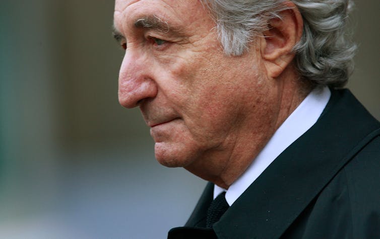 Man in a suit and tie, shown in profile, looks forlorn.