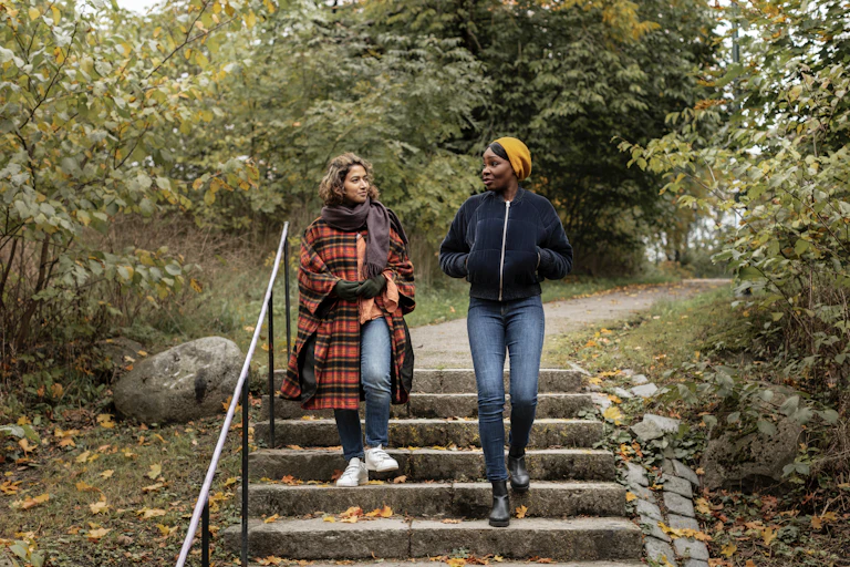 Two women walk in a park