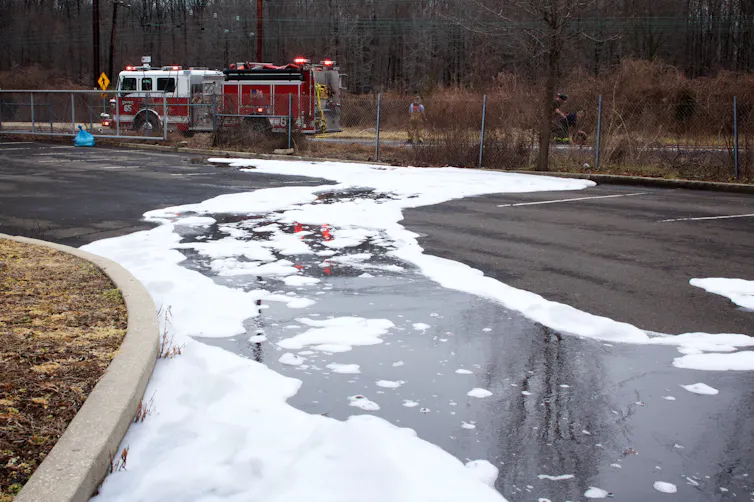 fire engine on road, firefighting foams spilling across it.