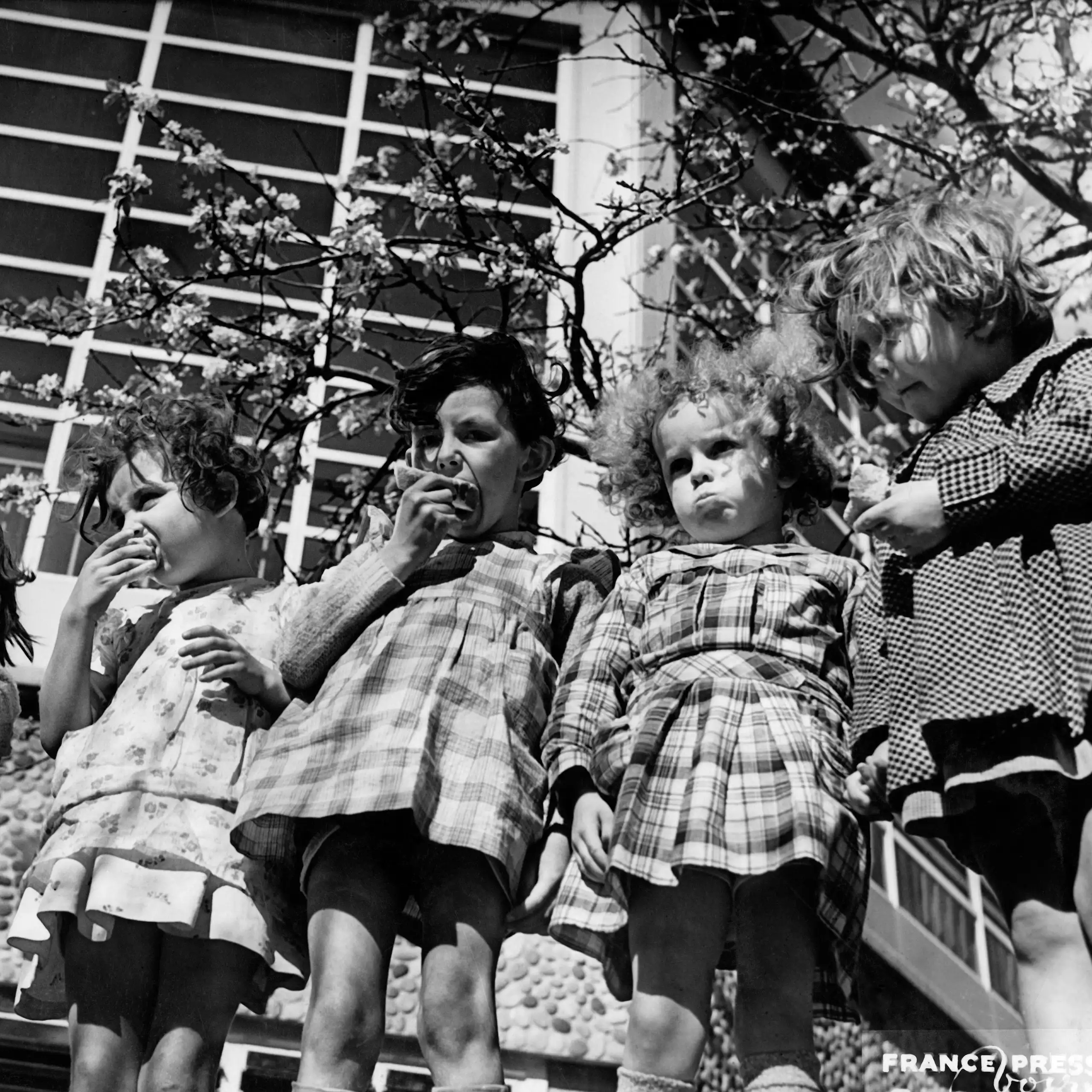 Des élèves prennent leur goûter dans la cour de l'école pilote de Suresnes, dans les années 1930.