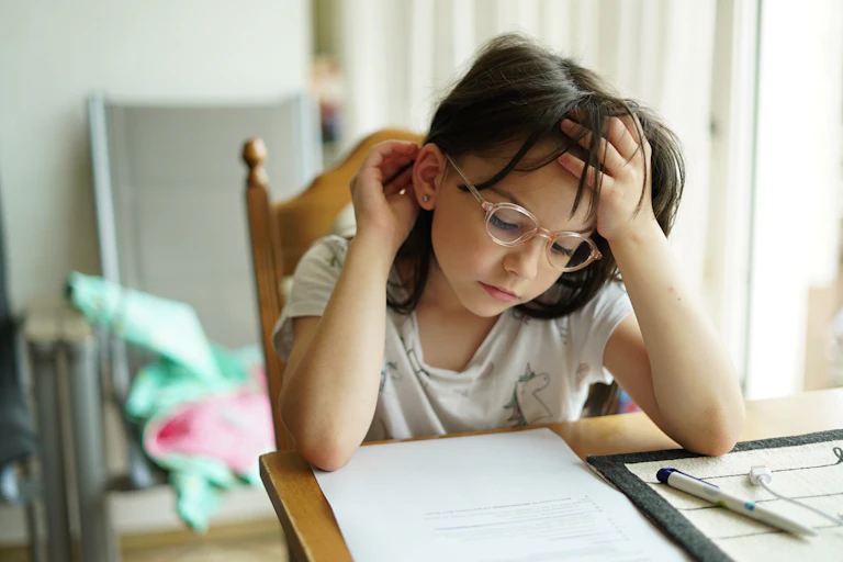 Little girl in glasses doing homework