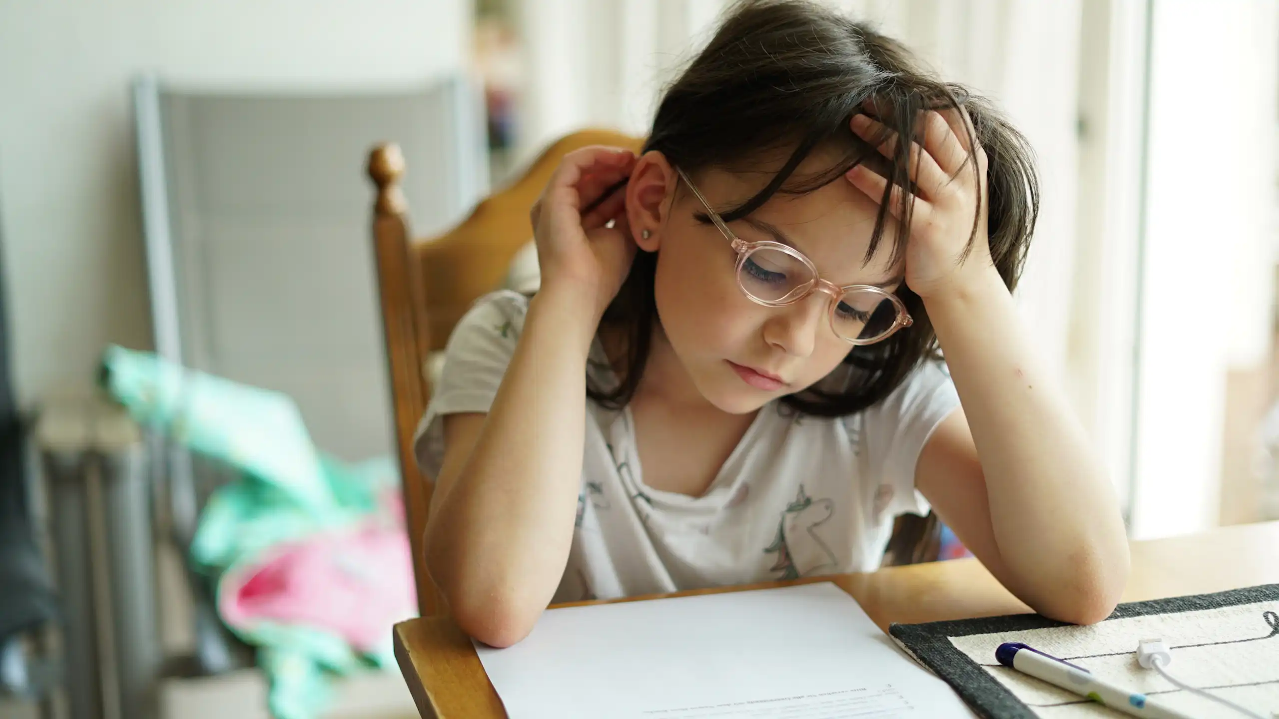 Little girl in glasses doing homework