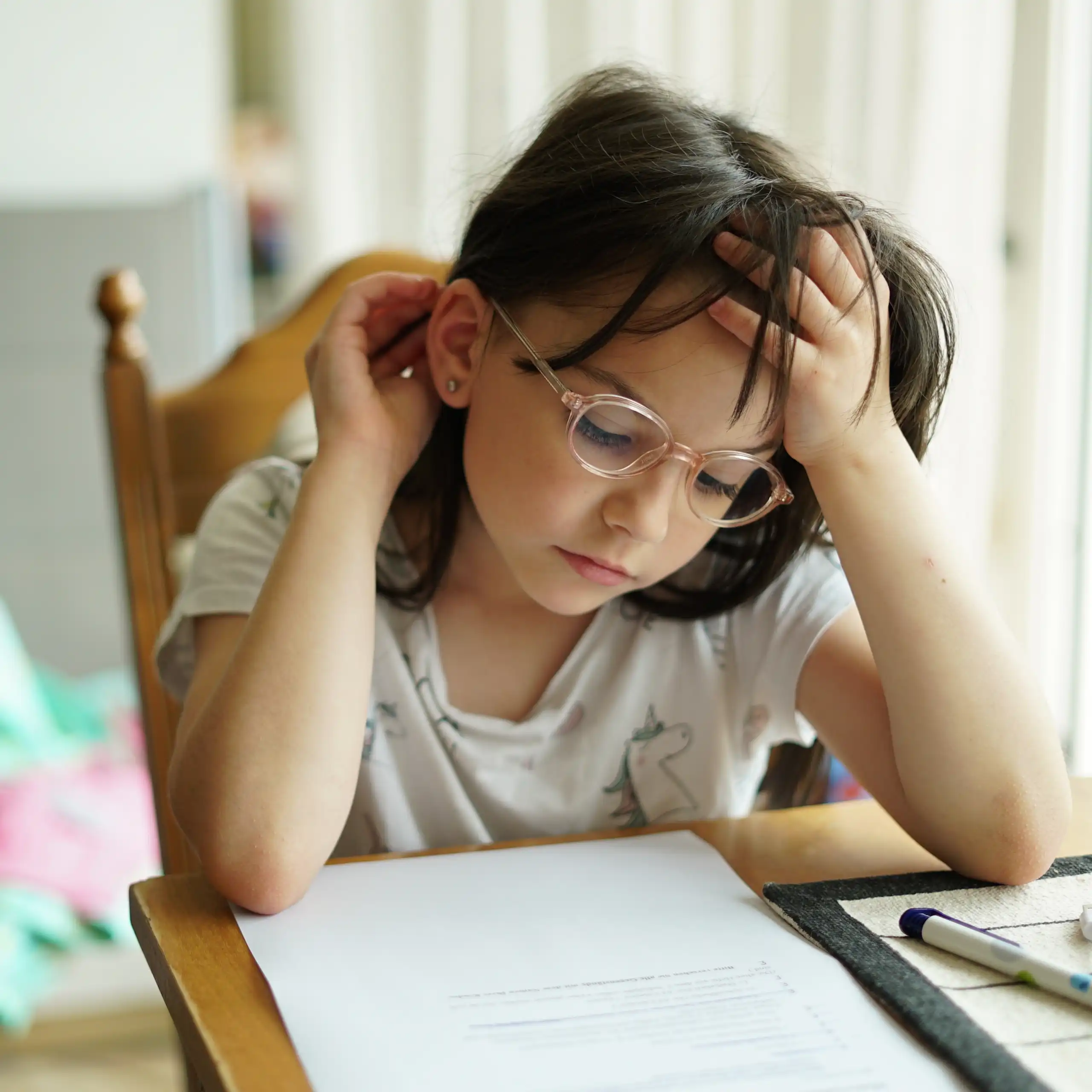 Little girl in glasses doing homework