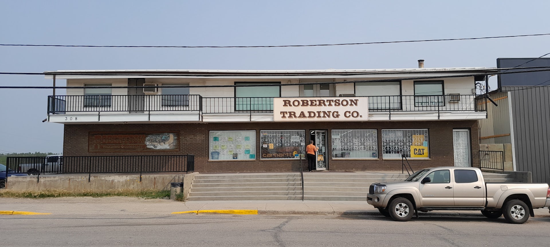 a small two-storey building with a sign reading Robertson trading co. 