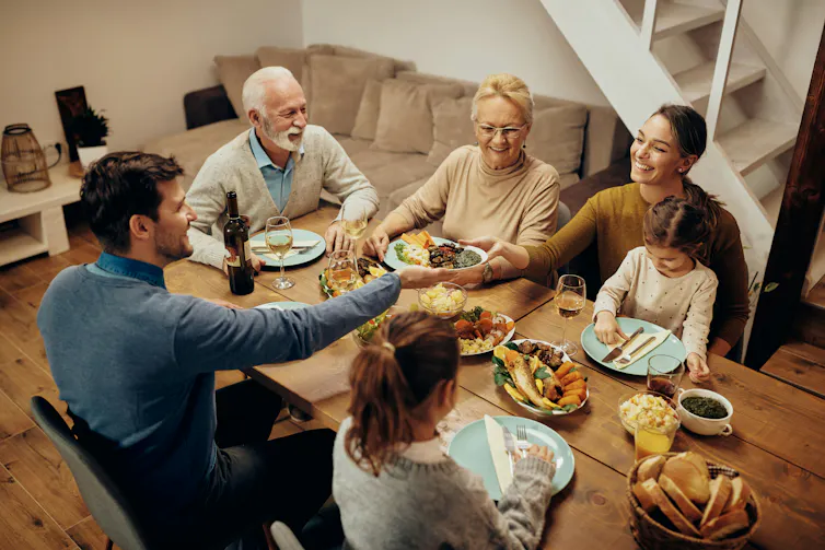 A happy extended family sitting around a table enjoying a meal