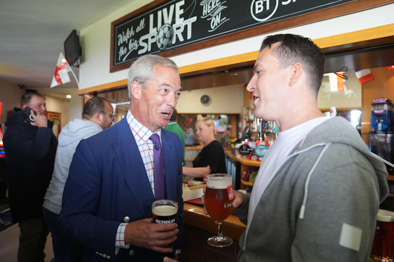 Nigel Farage chatting to a man over a pint.