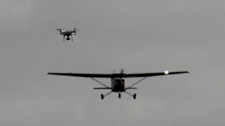 A drone and a small airplane in the air near each other
