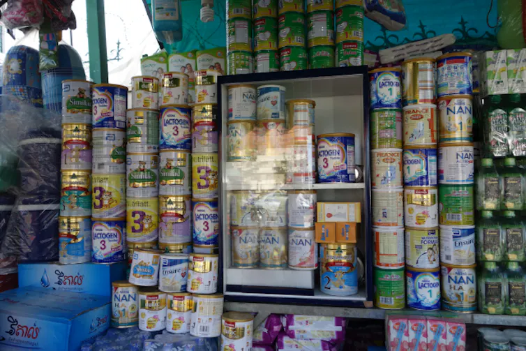 Des boites de lait artificiel et des produits de puériculture sur un étalage, Phnom Penh, Cambodge