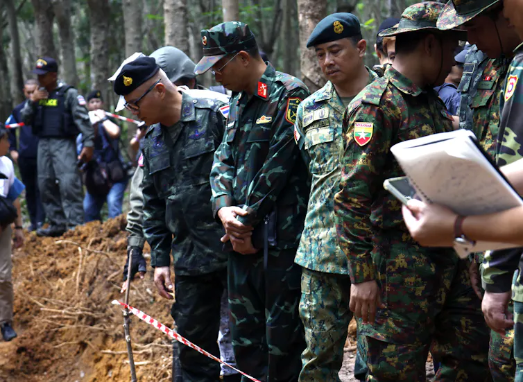 An team of military representatives from south-east Asia in a forest.
