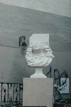 a bust with the top half showing a paper saying loading