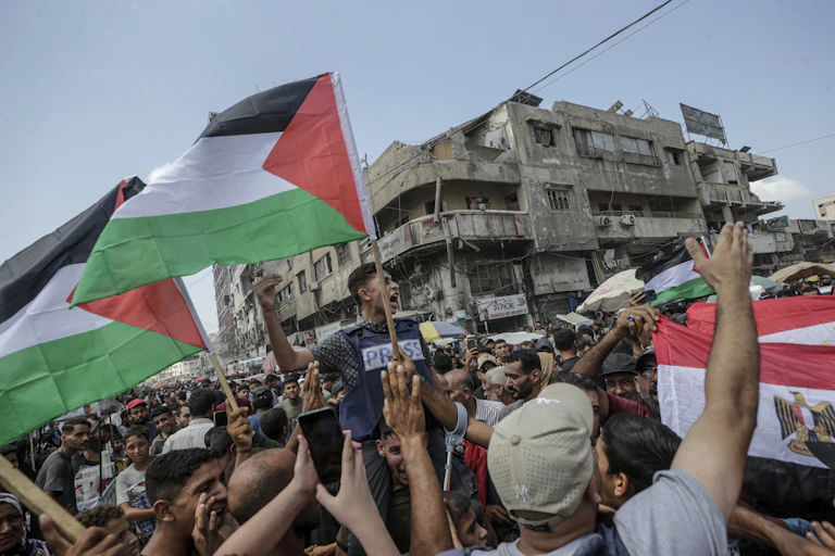 People waving Palestinian flags at a protest in Gaza City.